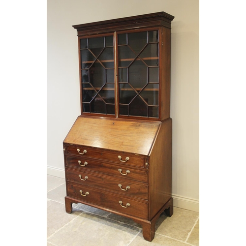 637 - A 19th century mahogany bureau bookcase, the dentil cornice above a pair of astragal glazed doors en... 