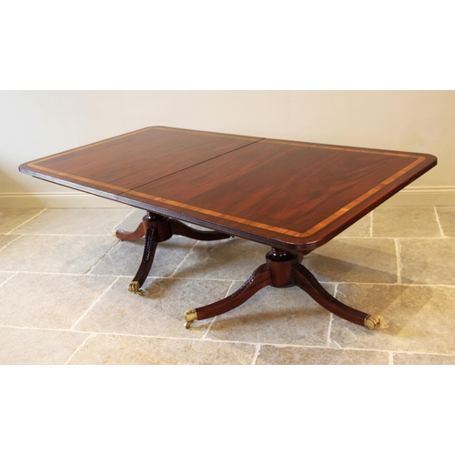 641 - A Regency style twin pillar mahogany dining table, late 20th century, the rectangular satinwood cros... 