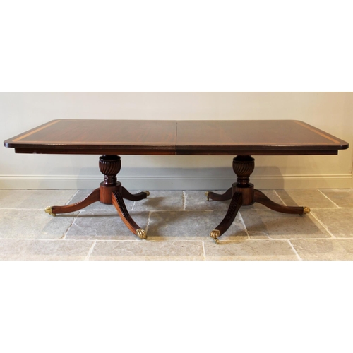 641 - A Regency style twin pillar mahogany dining table, late 20th century, the rectangular satinwood cros... 