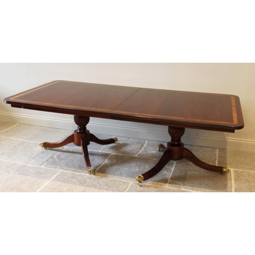 641 - A Regency style twin pillar mahogany dining table, late 20th century, the rectangular satinwood cros... 