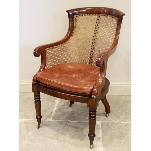 642 - A late Regency mahogany bergère tub chair, the shaped back extending to down swept arms enclosing th... 