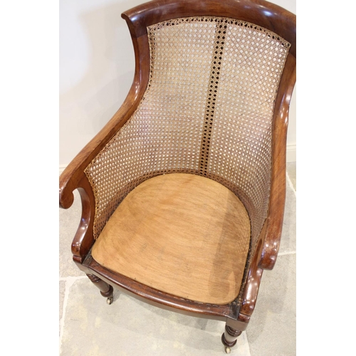 642 - A late Regency mahogany bergère tub chair, the shaped back extending to down swept arms enclosing th... 