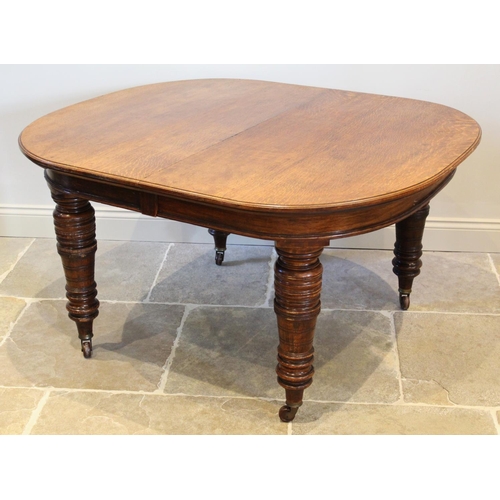 654 - A Victorian oak extending dining table, the oval top raised upon substantial ring turned tapering le... 