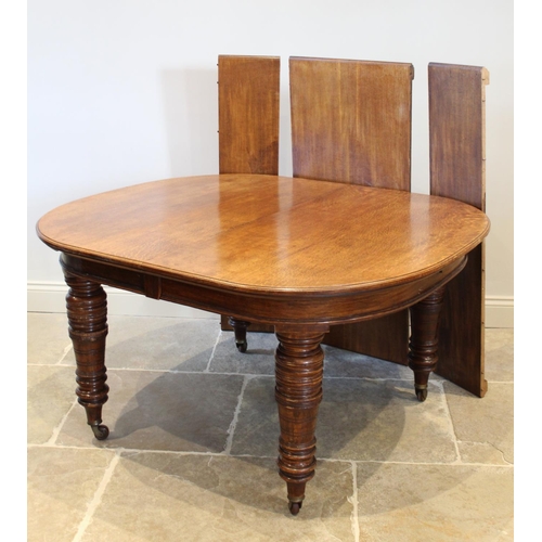 654 - A Victorian oak extending dining table, the oval top raised upon substantial ring turned tapering le... 