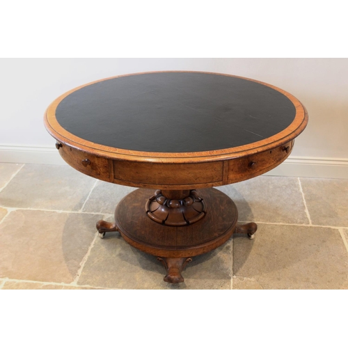 664 - A mid 19th century golden oak library drum table, the moulded circular top with an inset skiver, abo... 