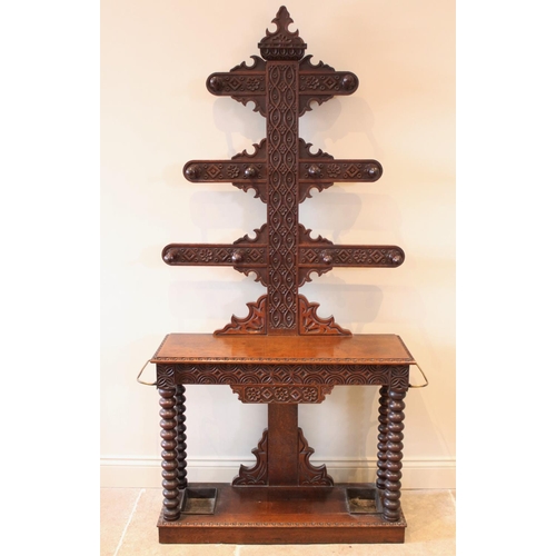 667 - A 17th century style carved oak tree form hall stand, late 19th century, with three graduated branch... 