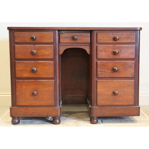 668 - A Victorian mahogany kneehole dressing table, the arched mirrored plate raised upon carved supports ... 