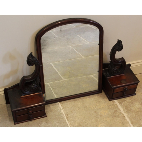 668 - A Victorian mahogany kneehole dressing table, the arched mirrored plate raised upon carved supports ... 