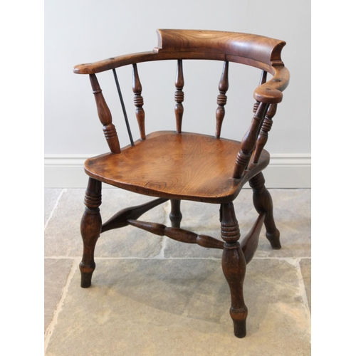 678 - A late 19th century elm and beech smokers bow elbow chair, the 'C' shaped top rail raised upon turne... 