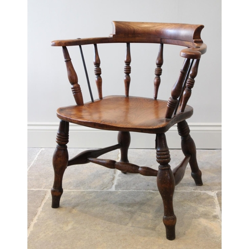 678 - A late 19th century elm and beech smokers bow elbow chair, the 'C' shaped top rail raised upon turne... 