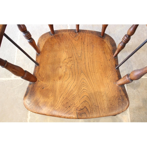 678 - A late 19th century elm and beech smokers bow elbow chair, the 'C' shaped top rail raised upon turne... 