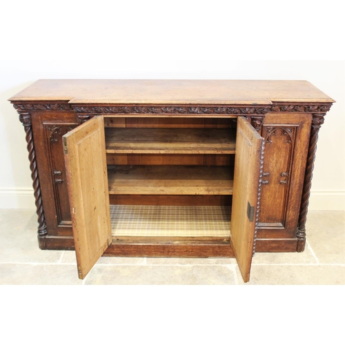 690 - A late 19th century oak Gothic influence breakfront credenza/sideboard, the moulded top above a carv... 