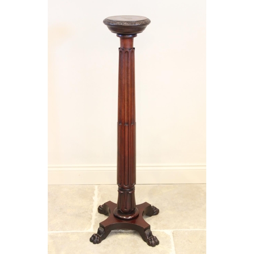 697 - A 19th century mahogany torchere, the 25cm top with a carved frieze raised upon a reeded and lobed a... 