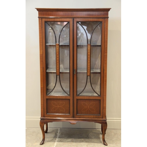 717 - An Edwardian inlaid mahogany display cabinet, the pair of glazed doors centred with a panel inlaid w... 