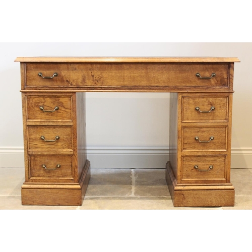 718 - A reproduction honey oak twin pedestal desk, late 20th century, the rectangular moulded top inset wi... 