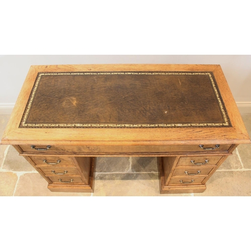 718 - A reproduction honey oak twin pedestal desk, late 20th century, the rectangular moulded top inset wi... 