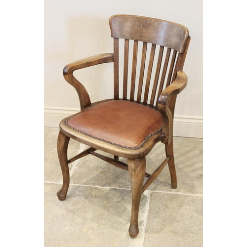 719 - An early 20th century stained beech wood desk chair, the lath back above a shaped padded seat applie... 