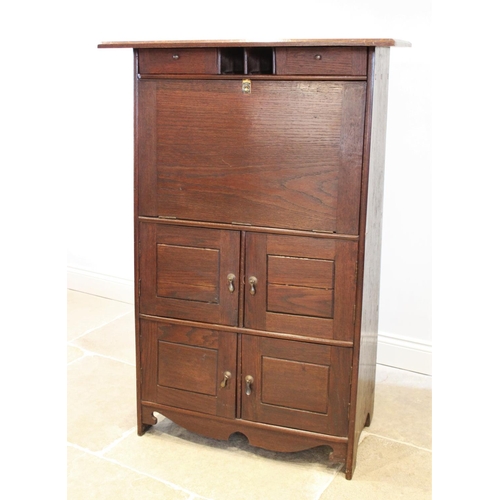 722 - An early 20th century Arts and Crafts oak secretaire abattant, of tapering form, the overhanging cor... 