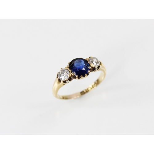 89 - An Edwardian sapphire and diamond three stone ring, comprising a round mixed cut sapphire measuring ... 