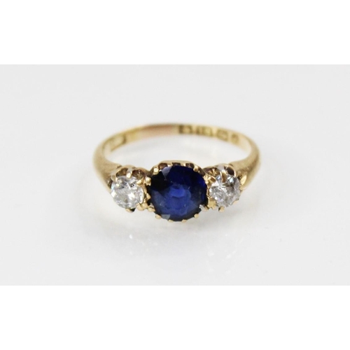 89 - An Edwardian sapphire and diamond three stone ring, comprising a round mixed cut sapphire measuring ... 