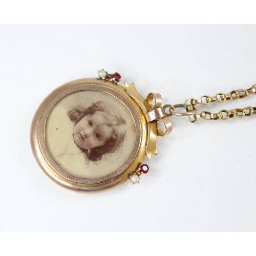 93 - An Edwardian 9ct gold picture pendant, of circular form surmounted by a bow, set with small rubies a... 