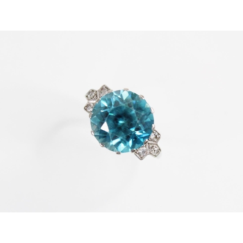 143 - An Art Deco blue zircon and diamond ring, the central round mixed cut zircon (measuring 12mm diamete... 