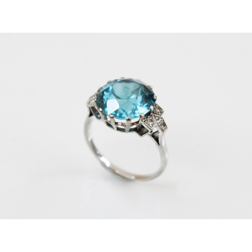 143 - An Art Deco blue zircon and diamond ring, the central round mixed cut zircon (measuring 12mm diamete... 