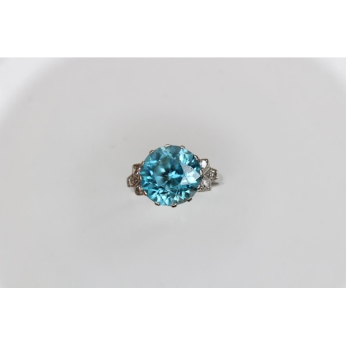 143 - An Art Deco blue zircon and diamond ring, the central round mixed cut zircon (measuring 12mm diamete... 