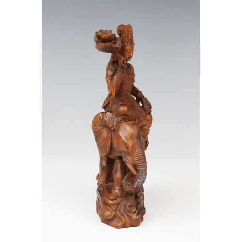 286 - A Chinese sandalwood carving of Guanyin upon an elephant, 16.5cm high (at fault)