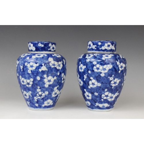 289 - A pair of Chinese blue and white prunus pattern vases and covers, each of slender baluster form, 21c... 