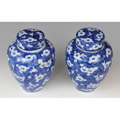 289 - A pair of Chinese blue and white prunus pattern vases and covers, each of slender baluster form, 21c... 