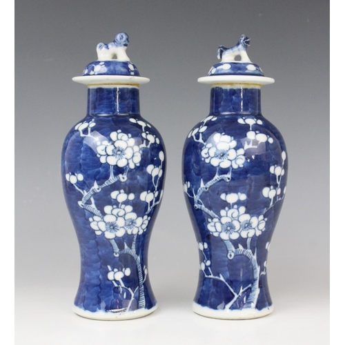 289 - A pair of Chinese blue and white prunus pattern vases and covers, each of slender baluster form, 21c... 