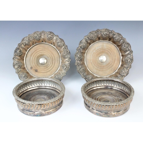 67 - A pair of white metal mid-19th century bottle coasters, each with turned circular mahogany bases wit... 