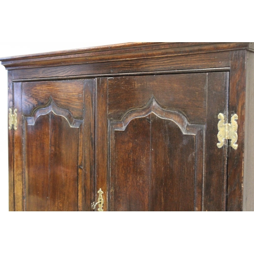 605 - A mid 18th century and later oak cabinet on stand, the moulded cornice above two fielded panel doors... 