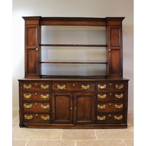 606 - A mid 18th century oak Welsh dresser, the inverted breakfront dresser rack with a moulded cornice ov... 