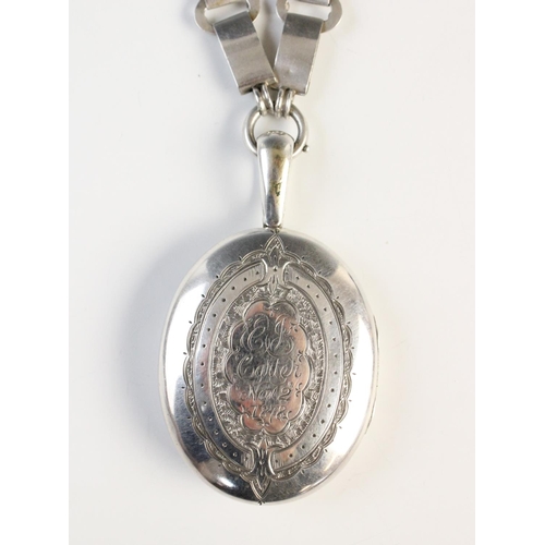 87 - A Victorian locket, of oval form with engraved floral decoration, inscription to reverse 'EJ Carter ... 