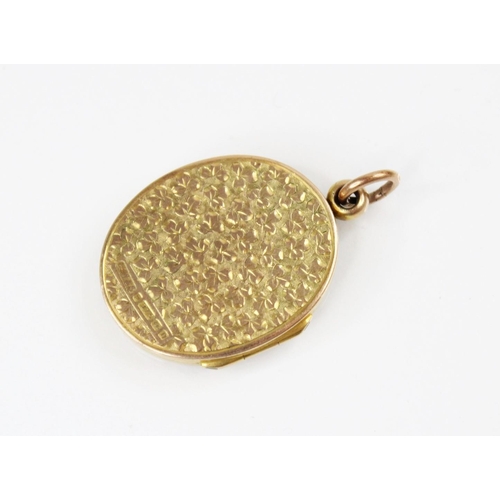 91 - A George V 9ct gold locket pendant, of oval form, engraved with scrolling and foliate decoration, wi... 