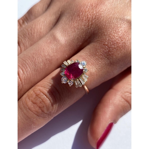 166 - A ruby and diamond cluster ring, the central rectangular cushion cut ruby (measuring 8.2 x 6.6 x 4.0... 