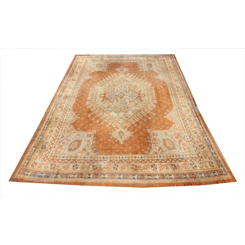 389 - A large Turkish wool carpet, in orange and cream colourways with a larger central medallion, 406cm x... 