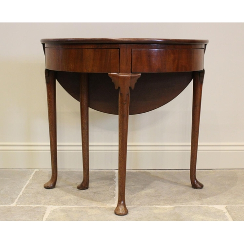 604 - A mid 18th century mahogany folding tea table, the demi-lune folding top above two hinged drawers, r... 