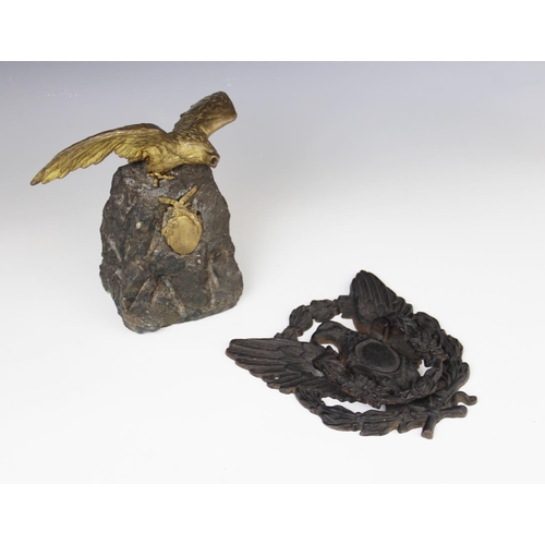 386 - An early 20th century gilt metal figure of an eagle above a ribbon tied oval cartouche, mounted upon... 