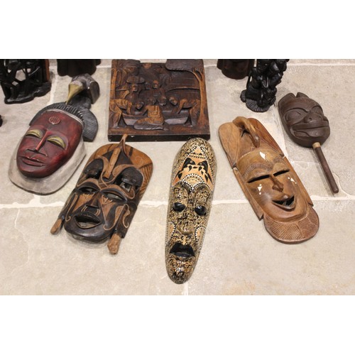 312 - A collection of Tribal carvings, predominantly from East Africa, to include a carved panel, 36cm x 3... 