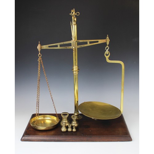 422 - An early 20th century set of Avery balance scales, the polished brass frame mounted on a rectangular... 