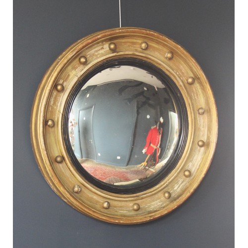 569 - A 19th century circular convex wall mirror, the gilt wood moulded frame applied with bead detail and... 