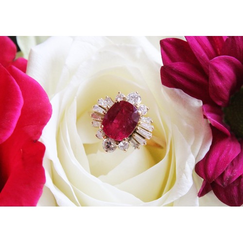 166 - A ruby and diamond cluster ring, the central rectangular cushion cut ruby (measuring 8.2 x 6.6 x 4.0... 