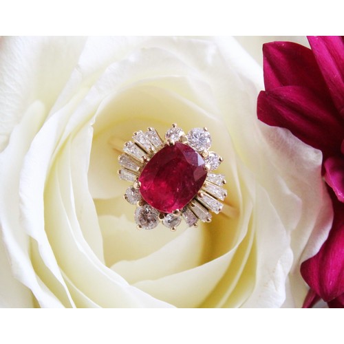 166 - A ruby and diamond cluster ring, the central rectangular cushion cut ruby (measuring 8.2 x 6.6 x 4.0... 