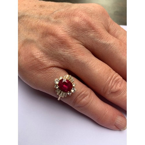 166 - A ruby and diamond cluster ring, the central rectangular cushion cut ruby (measuring 8.2 x 6.6 x 4.0... 