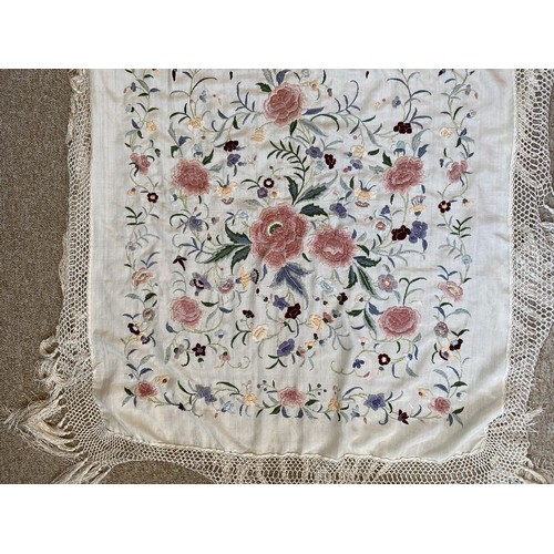 402 - A Chinese polychrome florally decorated machine embroidered silk piano shawl, against a cream ground... 