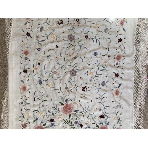 402 - A Chinese polychrome florally decorated machine embroidered silk piano shawl, against a cream ground... 