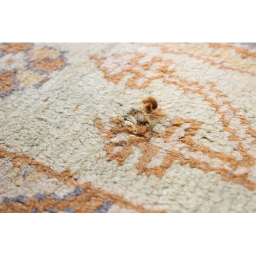 389 - A large Turkish wool carpet, in orange and cream colourways with a larger central medallion, 406cm x... 